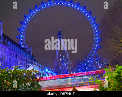 Das London Eye in der Nacht mit unscharfen London red Bus vorbei im Vordergrund South Bank London, England UK Stockfoto