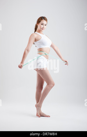 eine gesund aussehende Frau mit Maßband um den Körper Stockfoto