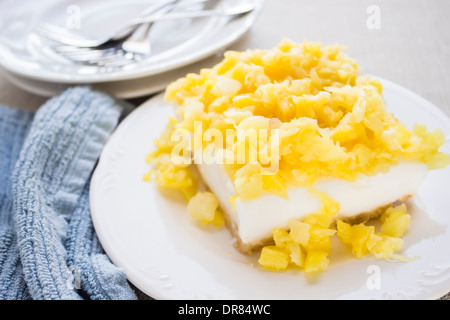 Cremiges Kokos Pudding Kuchen auf Macadamia-Nuss-Kruste und gekrönt mit gehackte Ananas Stockfoto