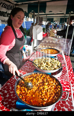 Londoner Markt Garküche. Markt Händler Anbieter in Canary Wharf, Kochen (Chorizo Eintopf) (Pan Fried geheilt Kabeljau mit Kartoffeln). Streetfood London. Stockfoto