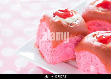 Bunten rosa Kokos Guave süße Brötchen mit Frischkäse-Vanillepudding gefüllt und garniert mit Guave-Saft-Konzentrat Stockfoto