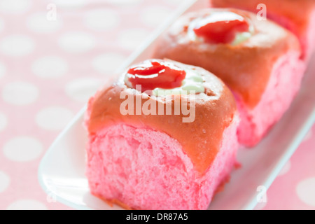 Bunten rosa Kokos Guave süße Brötchen mit Frischkäse-Vanillepudding gefüllt und garniert mit Guave-Saft-Konzentrat Stockfoto