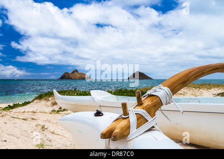 Ein Ausleger-Kanu sitzt am Ufer von Lanikai Strand vor Na Mokulua Inseln auf Oahu, Hawaii Stockfoto