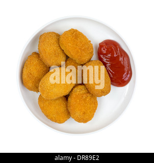 Eine kleine Portion gekochte panierte Hähnchenstücke mit Ketchup auf einen kleinen Teller. Stockfoto