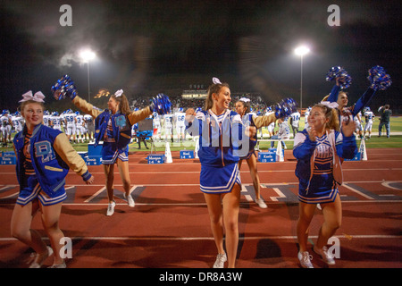 Cheerleader unterhalten die Zuschauer bei einem Fußballspiel Gymnasium Nacht in San Juan Capistrano, Kalifornien. Stockfoto