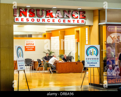 Versicherungsagenten beraten Affordable Car Act oder Obamacare, nannte bedeckt California im Zustand bei einem Laguna Hills, CA, Shopping-Mall Shop. Beachten Sie die Schilder am Eingang. Stockfoto