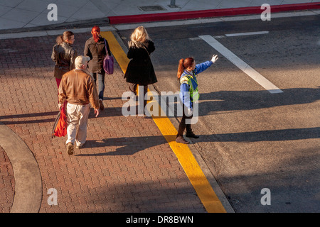 Ein asiatisch-amerikanische Polizeibeamter regelt den Verkehr auf dem Campus der University of California in Irvine. Beachten Sie die hellen Morgen Licht- und Sichtverhältnissen Sicherheitskleidung. Stockfoto