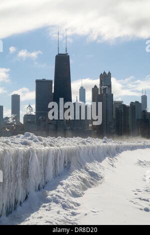 Chicago, USA. 21. Januar 2014.  Eiszapfen, gebildet von den Wellen aus dem neuesten Seeeffekt-Sturm drapieren die Ufermauer am Nordstrand Allee wie Schnee weht vor der Skyline der Stadt Innenstadt. Die Polarwirbel zurückgekehrt eisige Temperaturen zu bringen. Bildnachweis: Todd Bannor/Alamy Live-Nachrichten Stockfoto