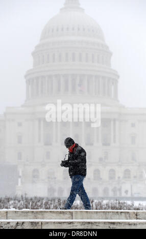 Washington DC, USA. 21. Januar 2014. Ein Mann geht vorbei an dem Kapitol in Washington DC, USA, 21. Januar 2014. Tausende von Flügen wurden abgesagt, Schüler erwischte einen zusätzlichen Tag von der Schule oder wurden früh nach Hause geschickt, und die Bundesregierung geschlossen seine Büros in der Washington Gegend Dienstag als einem Wintersturm Bohrung unten an der Ostküste. Bildnachweis: Yin Bogu/Xinhua/Alamy Live-Nachrichten Stockfoto
