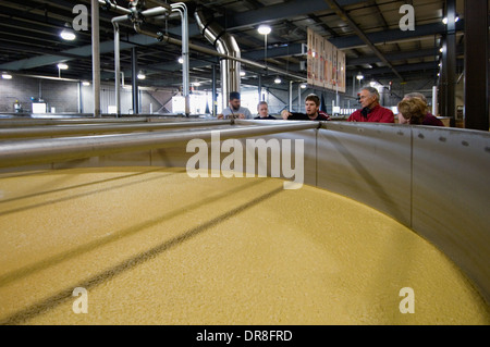 Anleitung erklärt den Prozess der Herstellung von Bourbon, Touristen neben Sour Mash gären in Stahl Wanne in wilder Truthahn Destillerie Stockfoto