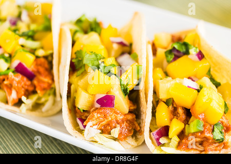 Mais-Tortillas gefüllt mit Blattsalat, zerkleinerte Grill Huhn und gekrönt mit Mango-Ananas-salsa Stockfoto