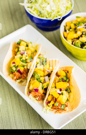 Mais-Tortillas gefüllt mit Blattsalat, zerkleinerte Grill Huhn und gekrönt mit Mango-Ananas-salsa Stockfoto