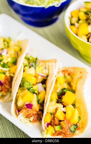 Mais-Tortillas gefüllt mit Blattsalat, zerkleinerte Grill Huhn und gekrönt mit Mango-Ananas-salsa Stockfoto