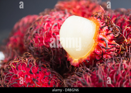 Rambutan ist ein tropischer süß und sauer, weiße, durchscheinende Früchte mit einem roten ledrige Haut mit haarigen Auswüchse. Stockfoto