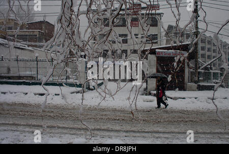 Srinagar, indisch verwalteten Teil Kaschmirs 22 Januar: A Kashmiri Frau Spaziergänge inmitten von Schneeflocken am Ufer des Dal-See nach Neuschnee am 22. Januar 2014 in Srinagar, Indien verwalteten Kaschmir, Indien. Mehrere Teile der einschließlich der Sommerhauptstadt Srinagar, Kaschmir-Tal erlebt Neuschnee heute, woraufhin die Behörden erteilen eine Lawine Warnung und führt bis zur Schließung der Autobahn Jammu-Srinagar, die einzige Straßenverbindung zwischen Kaschmir und Rest von Indien. (Sofi Suhail / Alamy Live News) Stockfoto