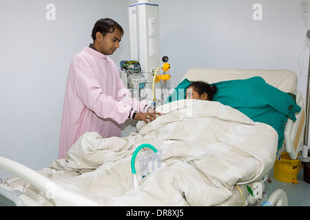 Ein Arzt behandelt ein Krebspatient in Krebs Fachkrankenhaus im Muni Seva Ashram in Bilgoraj, in der Nähe von Vadodara, Indien Stockfoto