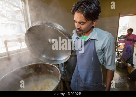 Köche, die Zubereitung von Speisen mit Solarkochern im The Muni Seva Ashram in Bilgoraj, in der Nähe von Vadodara, Indien Stockfoto