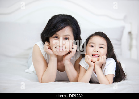 eine Frau und Enkelin auf einem Bett liegend Stockfoto