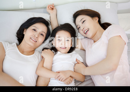 eine Frau mit Tochter und Enkelin auf einem Bett Stockfoto