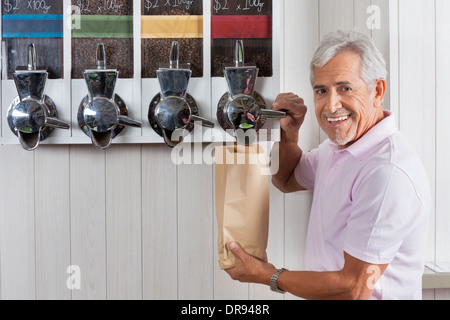 Senior woman Kaffeebohnen aus Automaten kaufen Stockfoto