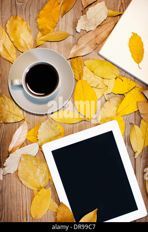 Tablet-PC und eine Tasse Kaffee auf Blätter im Herbst Stockfoto