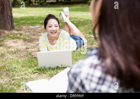 ein Student liegen auf dem Rasen mit laptop Stockfoto