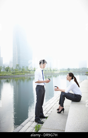 ein Geschäftsmann und ein Business-Frau neben einem Fluss Stockfoto