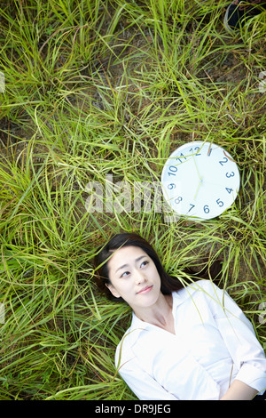 eine Frau liegt auf dem Rasen Stockfoto