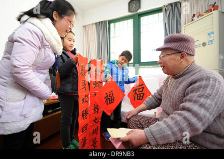 Hangzhou, China Zhejiang Provinz. 22. Januar 2014. Pan Xiaoyan (2 L), ein 8 - Jahre altes Mädchen und Chen Duanji (2. R), ein achtjährigen Jungen chinesischen Couplets geschrieben von sich ein Alter Mann Li Youlin, als Geschenke an die kommenden Frühlingsfest in Hangzhou, Hauptstadt der ostchinesischen Provinz Zhejiang, 22. Januar 2014 grüßen senden. Chinesen haben die Tradition, das Couplet zu beheben die roten scrollt mit gereimten Sprüchen auf ihre Türen während des Frühlingsfestes, hoffen, dass sie im Glück bringen kann. Das Frühlingsfest fällt am 31. Januar dieses Jahres. Bildnachweis: Ju Huanzong/Xinhua/Alamy Live-Nachrichten Stockfoto