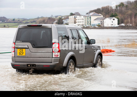 Eine Autofahrer fährt durch Hochwasser auf der Straße bei Storth an der Mündung der Kent in Cumbria, UK, während der Januar 2014 Stürme Stockfoto