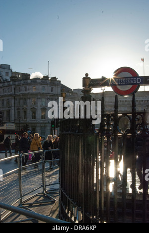 Aufnahme des Untergrundes Schild am Trafalgar Square in London; Sonne hinter dem Schild, Menschen im Hintergrund Fräsen Abfackeln. Stockfoto