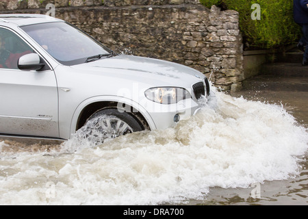 Eine Autofahrer fährt durch Hochwasser auf der Straße bei Storth an der Mündung der Kent in Cumbria, UK, während der Januar 2014 Stürme Stockfoto