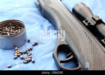 Teil von einem Luftgewehr und Pellets auf blauem Hintergrund Stockfoto