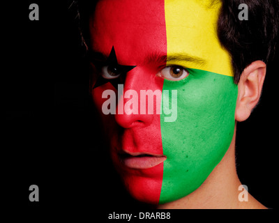 Flagge von Guinea-Bissau auf ein Gesicht eines jungen Mannes gemalt Stockfoto