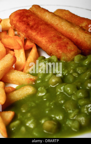 Fischstäbchen, Pommes und matschig Erbsen essen Stockfoto