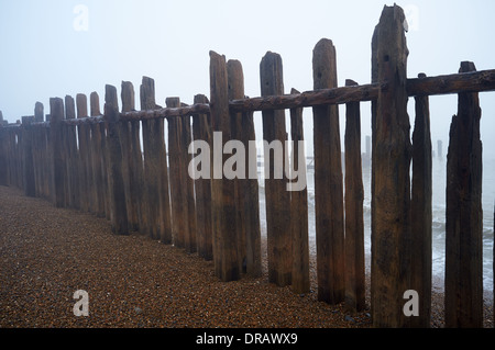 Hölzerne Buhnen im Nebel Stockfoto