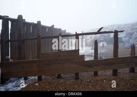 Hölzerne Buhnen im Nebel Stockfoto