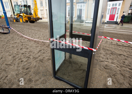 Nach einer Woche der Springfluten, Sturmfluten und Sturmwinde Kraft hat die Strandpromenade von Aberystwyth in Wales, mit Millionen von Pfund Schaden verwüstet. Die brechenden Wellen schlug ein großes Loch in den Deich und ist zusammengebrochen Aberystwyths kultigen, viktorianischen Promenade Unterschlupf, die seit über 100 Jahren stehen geblieben. Dieses Bild entstand auf Mittwoch, 8. Januar 2014, der Tag begann der Rat, zu versuchen, und deaktivieren Sie die Tausende von Tonnen Schutt Strand Meer Offroad. Stockfoto