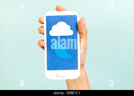 Konzeptionelle Telefon zeigt eine Wolke und Vogel auf blauem Hintergrund Stockfoto