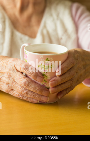 Ältere Dame in ihre neunziger Jahre halten Tasse Tee Stockfoto