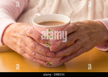 Ältere Dame in ihre neunziger Jahre halten Tasse Tee Stockfoto