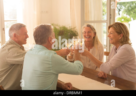 Senior Paare Toasten Weingläser am Tisch Stockfoto