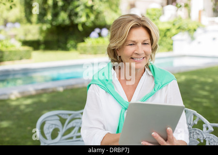 Ältere Frau mit digital-Tablette im Hinterhof Stockfoto