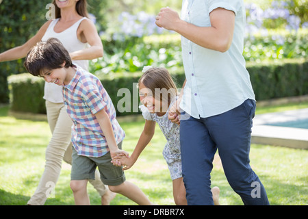 Familie Hand in Hand und läuft im Hinterhof Stockfoto