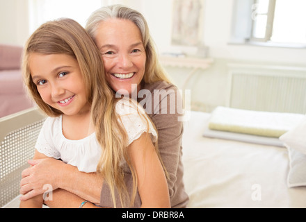 Großmutter umarmt Enkelin Stockfoto