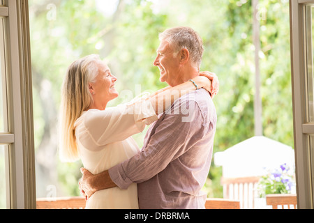 Älteres paar umarmt in Tür Stockfoto