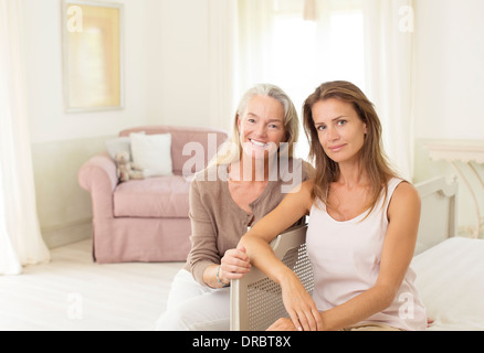 Mutter und Tochter lächelnd in Schlafzimmer Stockfoto