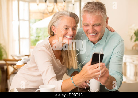 Älteres Paar Austausch von MP3-Player in der heimischen Küche Stockfoto