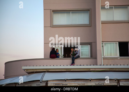 Leute haben auf Balkon trinken Point wie die Sonne untergeht in Mouille - Cape Town - Südafrika Stockfoto