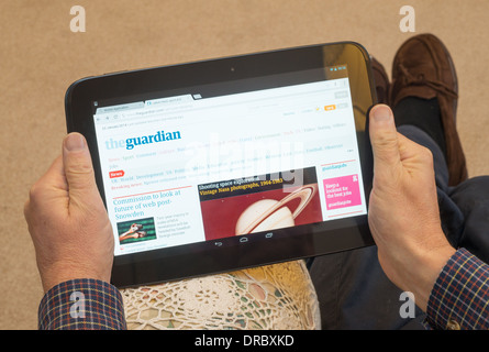 Mann liest Zeitung the Guardian mit Google Nexus 10 tablet Stockfoto